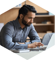 Male computer science teacher sitting at computer and participating in a training webinar